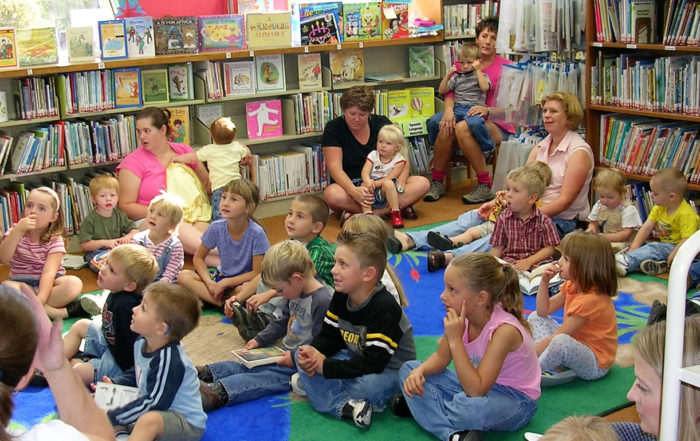 chlldren sitting on the floor of the Harney County Library listening to story hour