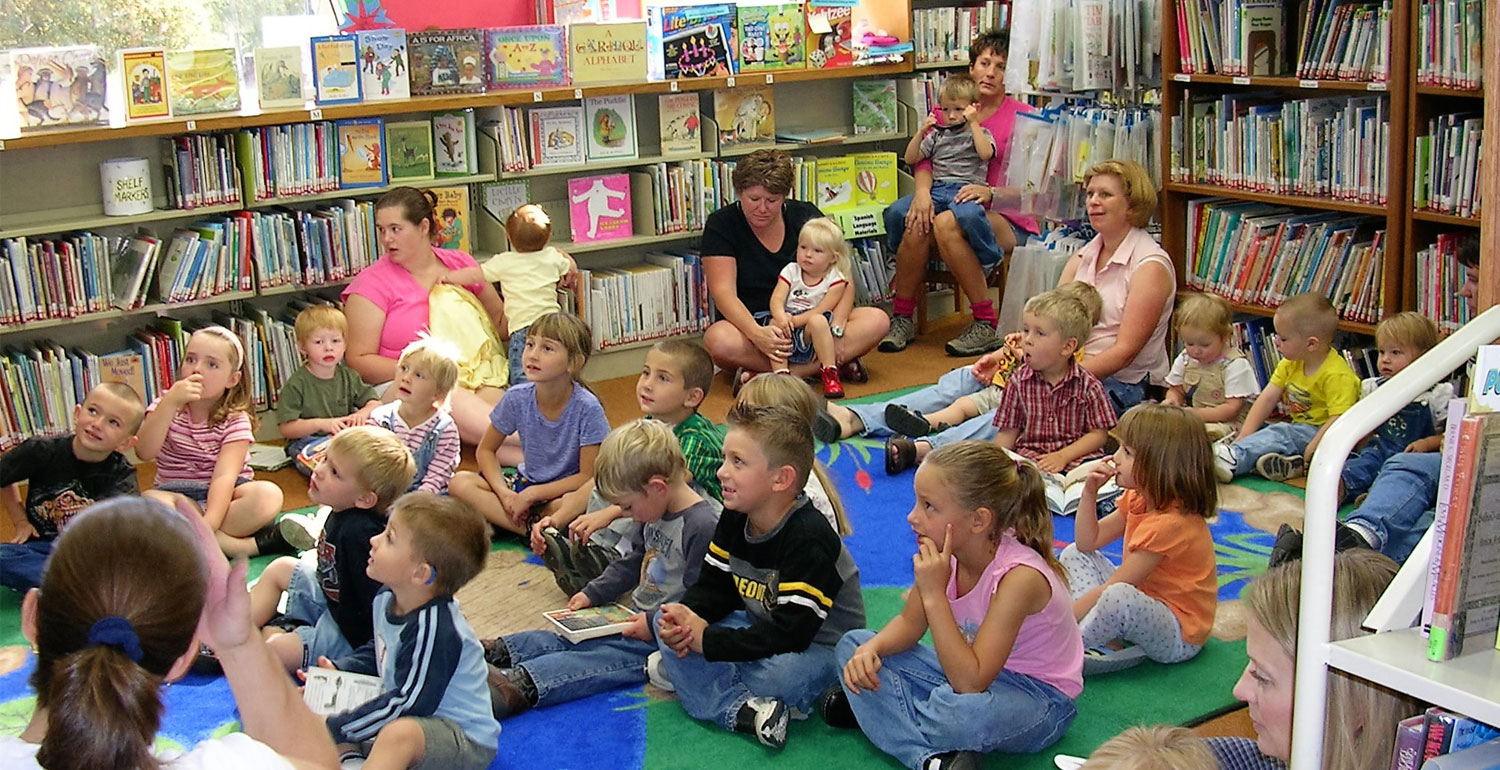 chlldren sitting on the floor of the Harney County Library listening to story hour